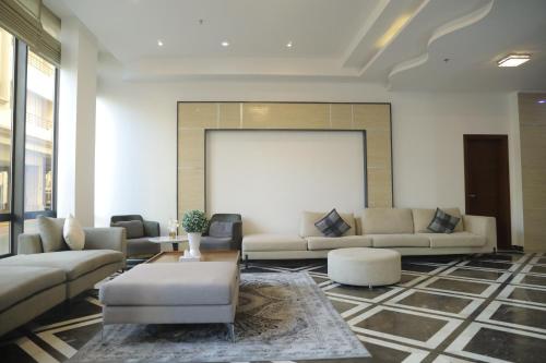 a living room with couches and a white screen at Empire Apartments in Juffair