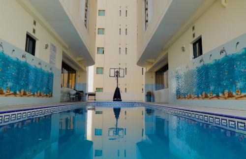 an indoor pool in a building with blue water at Empire Apartments in Juffair