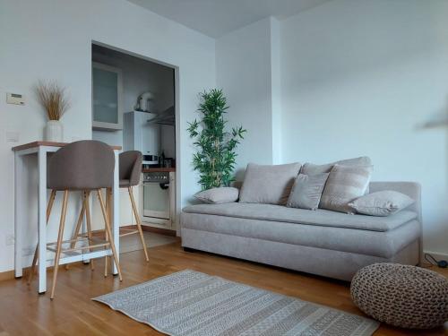a living room with a couch and a kitchen at Balcony Apartment, 5 min Walk to First District in Vienna