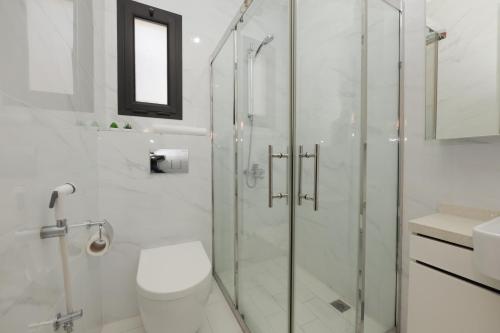 a bathroom with a shower and a toilet and a sink at Empire Apartments in Juffair