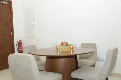a dining room table with chairs and a table at Empire Apartments in Juffair