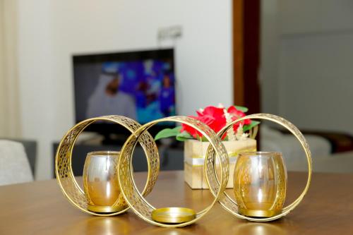 a group of three gold glasses on a table at Empire Apartments in Juffair