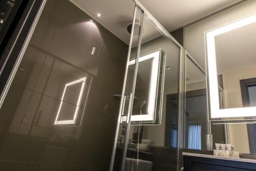 a bathroom with a glass shower with two windows at Ego Hotel in Ancona