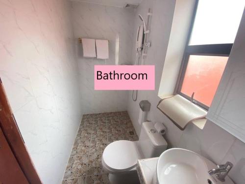 a bathroom with a white toilet and a sink at Khun Pich Apartments in Siem Reap