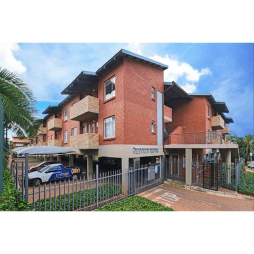 a large brick building with a car in front of it at Cosy apartment with secure parking in Johannesburg