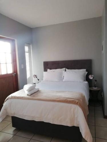 a bedroom with a large bed with two pillows on it at Cosy apartment with secure parking in Johannesburg