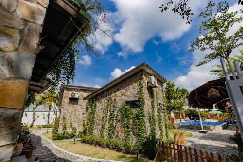 a stone building with ivy growing on it at Bến Đò Xưa Homestay & Coffee in Cái Răng