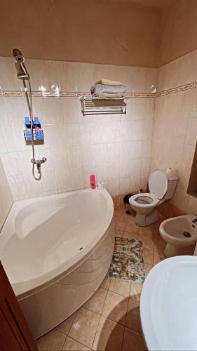 a bathroom with a tub and a toilet and a sink at Colombia Apartments&Rooms in Durrës