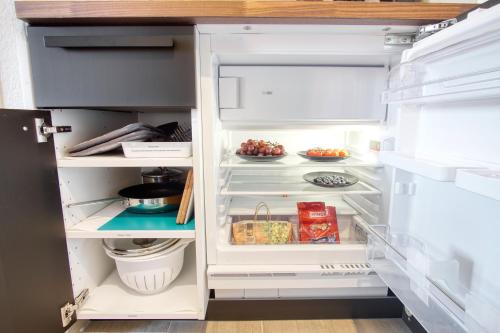 a refrigerator with its door open with food inside at HOMEFY - Business Apartment in Neuss