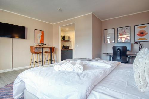 a bedroom with a large white bed with towels on it at HOMEFY - Business Apartment in Neuss
