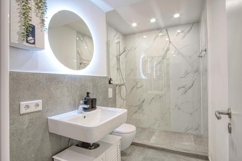 y baño blanco con lavabo y ducha. en Homefy Business Apartment - Messe - Düsseldorf - Balkon - Aufzug, en Neuss