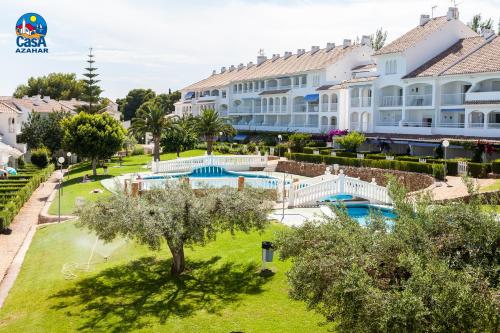 a resort with a swimming pool and a large building at Residencial Al Andalus Casa Azahar in Alcossebre