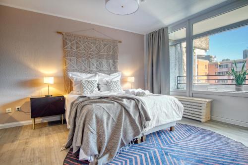 1 dormitorio con cama grande y ventana grande en Homefy Business Apartment - Messe - Düsseldorf - Balkon - Aufzug, en Neuss