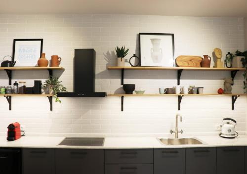 une cuisine avec un évier et des étagères au mur dans l'établissement Habitat Nafplio bnb-The Dreamers Apartment, à Nauplie