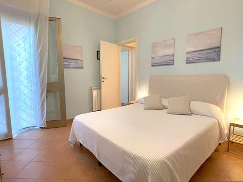 una camera da letto con un grande letto bianco con due cuscini di Villa DilettaMaria a Forte dei Marmi