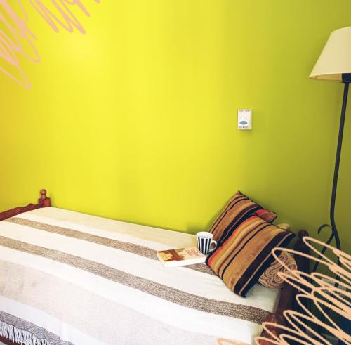 1 dormitorio con 1 cama con pared verde en Sorrentino Alquileres en Villa Carlos Paz