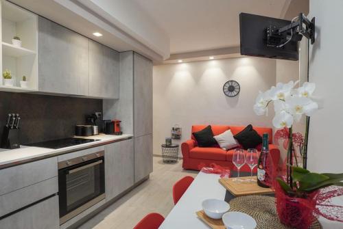 salon z czerwoną kanapą i stołem w obiekcie Modern Apartment on the Mt.Baldo & Garda Lake w mieście Brentonico
