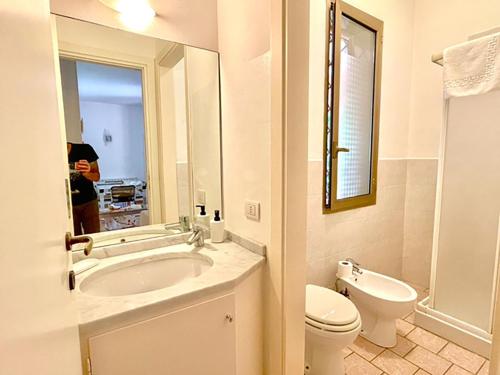 bagno con lavandino, servizi igienici e specchio di Villa DilettaMaria a Forte dei Marmi