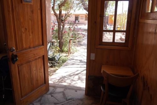 an open door with a table and a window at Hotel-Camping Takha Takha in San Pedro de Atacama