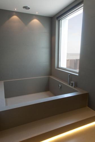 a bathroom with a large bath tub with a window at Ego Hotel in Ancona