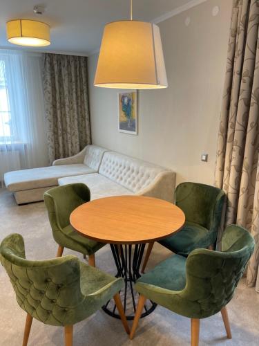 a living room with a table and chairs and a couch at Hotel Radetzky in Sankt Gilgen