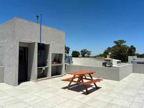un banc en bois assis au-dessus d'un toit dans l'établissement Gran departamento a metros de la laguna para parejas, à Chascomús