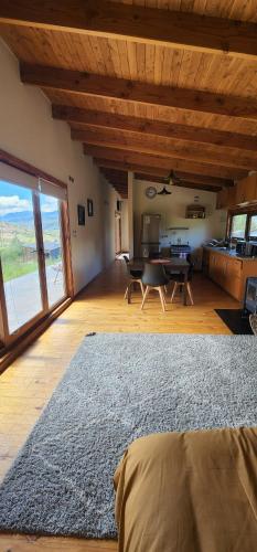 salon ze stołem i dużym dywanem w obiekcie Turismo y Cabañas Dragon de La Patagonia w mieście Cochrane