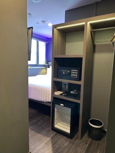 a small room with a bedroom with a bed at HOTEL JJH - newly opened near BUGIS in Singapore