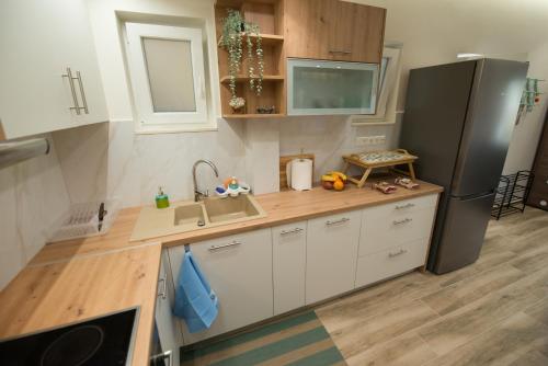 a small kitchen with a refrigerator and a sink at Brand new apartment with hidden garden in Athens