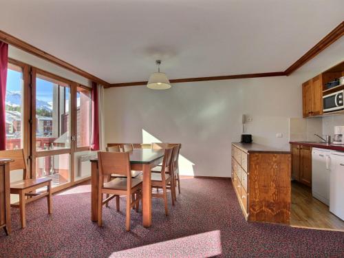 une cuisine et une salle à manger avec une table et des chaises dans l'établissement Grand 3 pièces spacieux, dernier étage, au pied des pistes, animaux admis - FR-1-455-204, à La Plagne Tarentaise