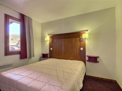 une chambre avec un grand lit et une fenêtre dans l'établissement Grand 3 pièces spacieux, dernier étage, au pied des pistes, animaux admis - FR-1-455-204, à La Plagne Tarentaise