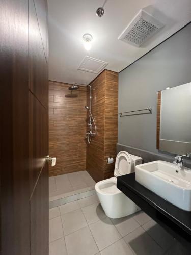 La salle de bains est pourvue de toilettes, d'un lavabo et d'une douche. dans l'établissement Le 10 The Radiance Manila Bay, à Manille