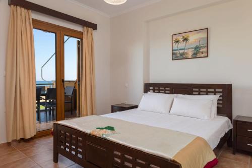 a bedroom with a bed with a view of the ocean at Venetico Beachfront Apartments & Suites - 2 Bedroom Sea View Suite in Argasi