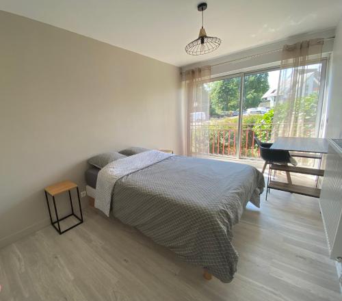 1 dormitorio con cama, escritorio y ventana en Magnifique appartement à deux pas du centre ville!, en Quimper