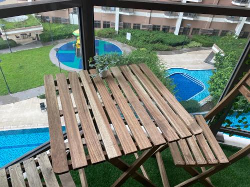 a wooden bench sitting next to a swimming pool at Le 10 The Radiance Manila Bay in Manila