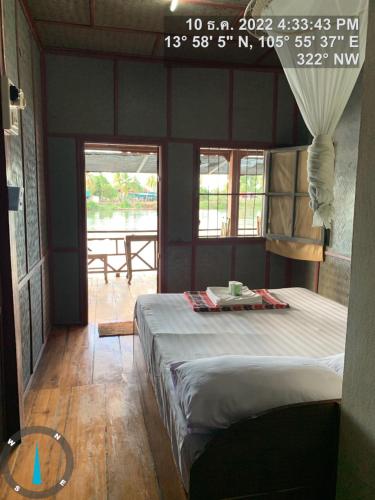 Muang KhôngにあるPa Kha Guesthouseのテーブル付きの部屋にベッドが備わる部屋