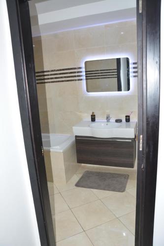 y baño con lavabo y espejo. en Magnifique Appartement Inès complexe Aida village, en Tánger