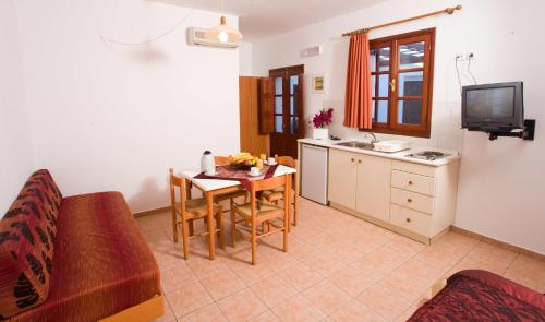 a living room with a table and a kitchen at Anastasia Studios Lindos in Lindos