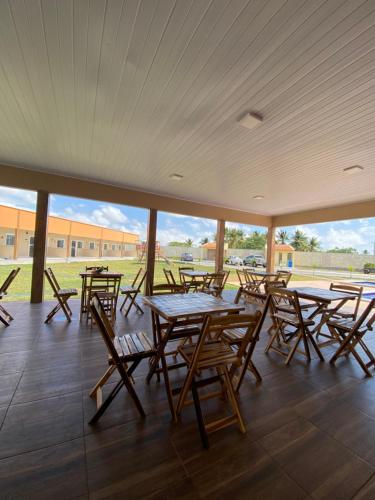 a group of tables and chairs in a pavilion at Pousada Vila das Lagoas in Santo Amaro