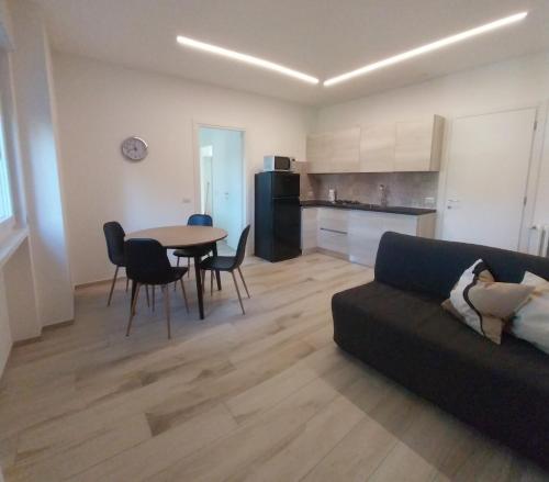 a living room with a couch and a table and a kitchen at Casa DelFalco in Domodossola