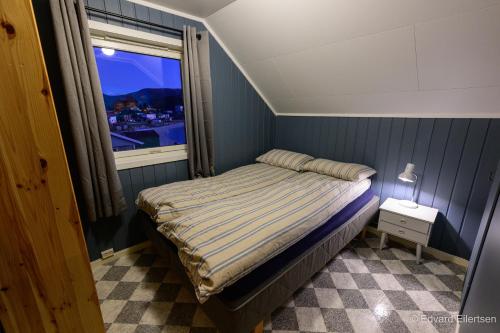 a small bedroom with a bed and a window at Cozy house on Sommarøy in Sommarøy
