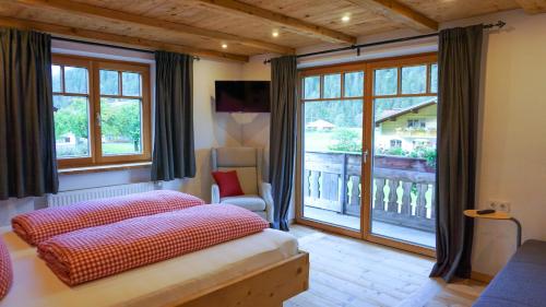 ein Schlafzimmer mit einem Bett und einem großen Fenster in der Unterkunft Haus Petra in Bach
