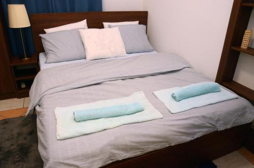 een bed met handdoeken en kussens erop bij Dorcoleta Apartment in Belgrado