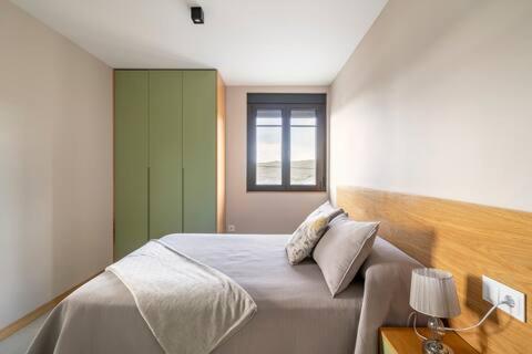 sypialnia z dużym łóżkiem i oknem w obiekcie APARTAMENTOS LAS OLAS BY PANTIN w mieście Valdoviño