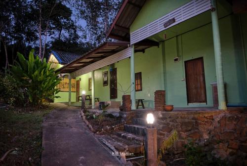 a house with a light on the side of it at Hill Station Hostel at Chor Chaba in Ko Kood