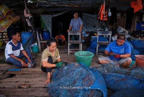 a group of people working on nets in a market at Hill Station Hostel at Chor Chaba in Ko Kood