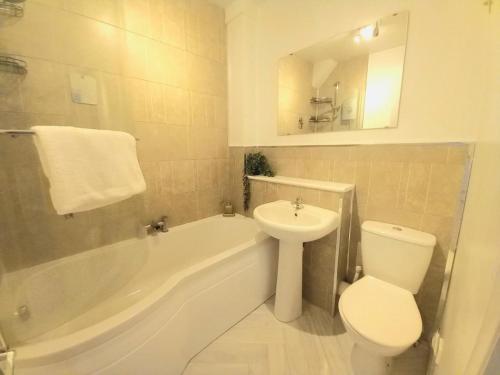 a bathroom with a sink and a toilet and a tub at Angel Lane Alnwick Apartment in Alnwick