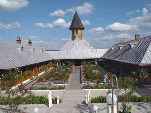 a building with a garden and a clock tower at Casa Adelin in Eşelniţa