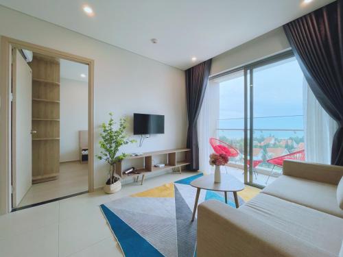 a living room with a couch and a large window at The Song Apartment Vung Tau Homestay Căn Hộ Biển in Vung Tau