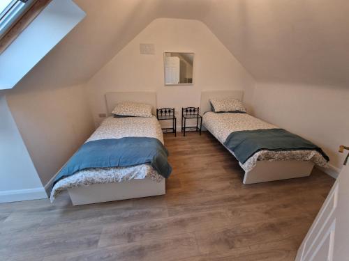 2 camas en un dormitorio ático con suelo de madera en The Gate House, Kilmullen en Portarlington